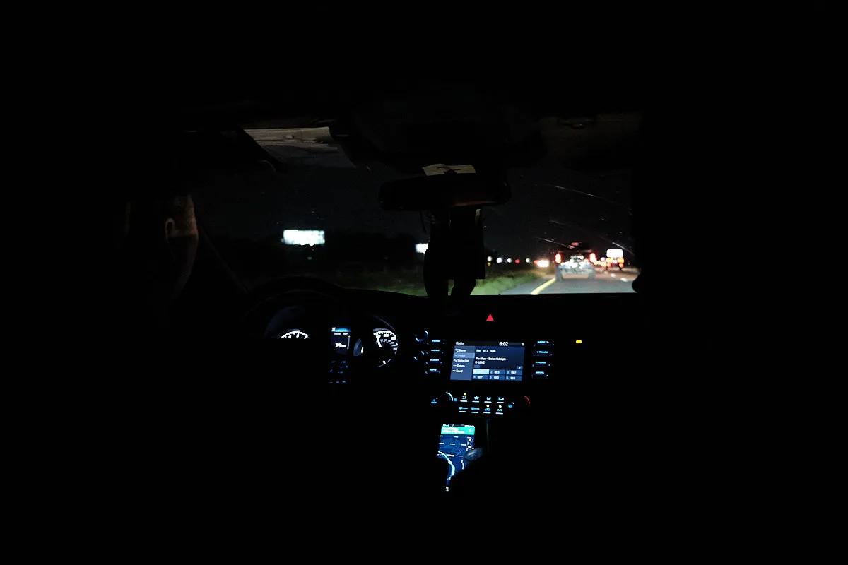 In the back seat of Johnna's sister's car. It's dark outside.