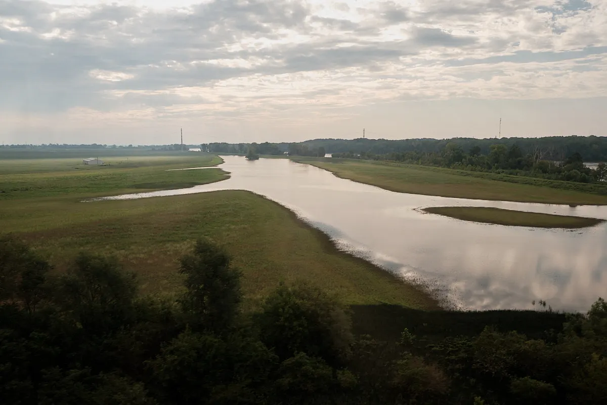 Looking out the train window at a flooded farm field.