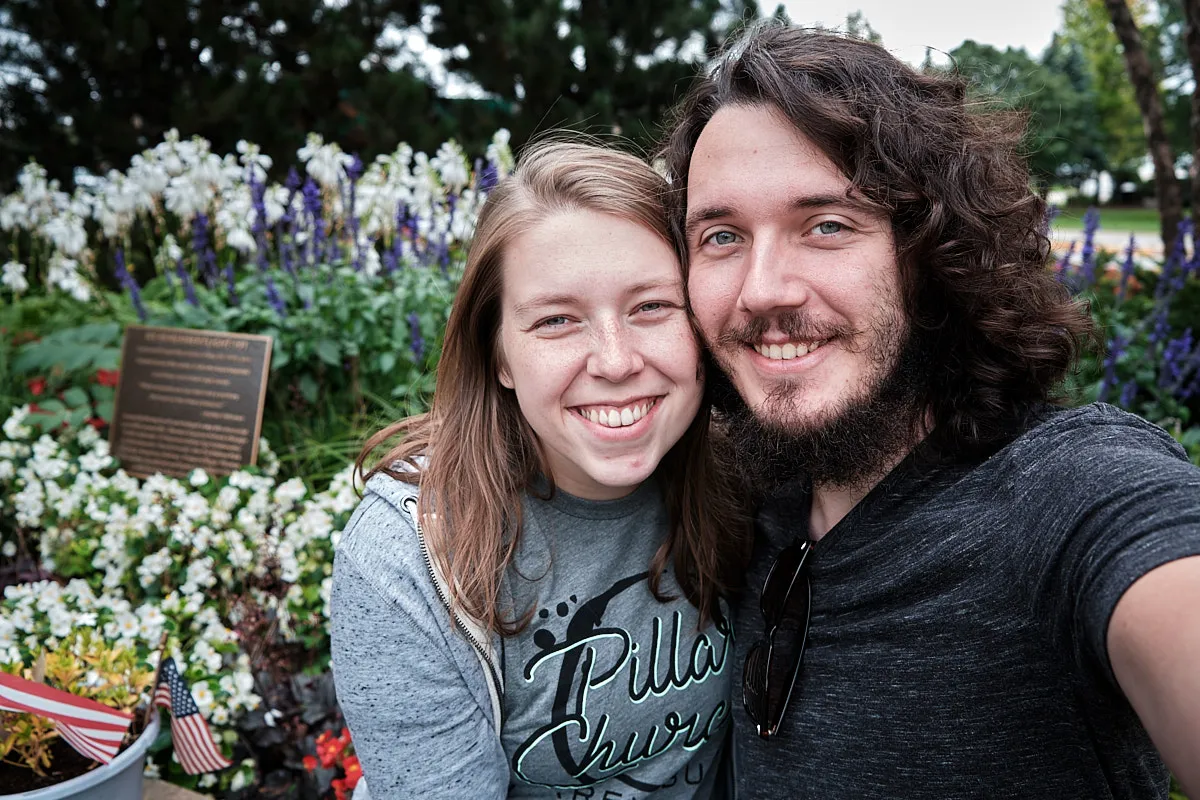 A selfie of Johnna and me in front of a floral background. We look happy and excited.