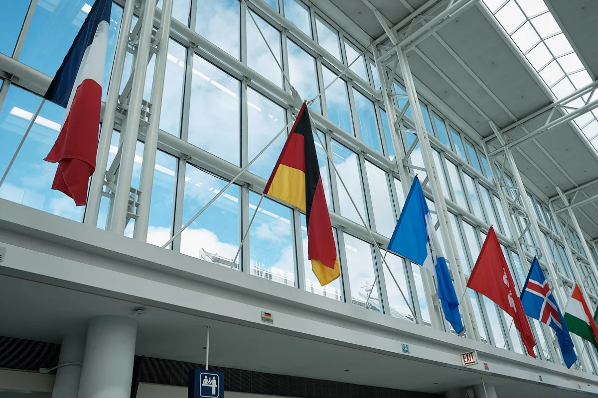 The flags lining the windows of Chicago O'Hare International Airport. Germany's flag is prominently featured in the middle of the frame.